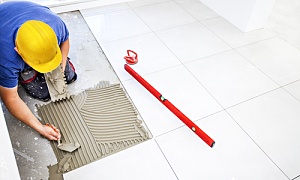 contractor working on tiling a bathroom floor