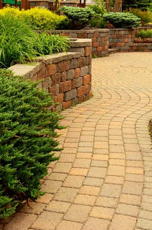 Combination of a retaining wall and landscaping that prevents flooding property