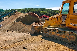 bulldozer moving dirt and preparing it for a delivery