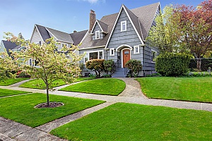 a nicely landscaped front yard of a house with fill dirt that builds up to the house like a hill so that the house can be properly drained of any water runoff so that there is no house flooding