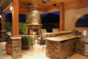 Outdoor patio kitchen with fireplace dining area