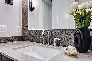 a new sink in a bathroom remodel that is equipped with a very modern backsplash