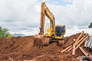 an excavator working with fill dirt to level out a site that was approved to operate on after a safety inspection
