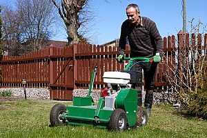 a man aerating his lawn in preparation of the snow as well as his fill dirt project that he will receive the help of a Virginia fill dirt contractor for