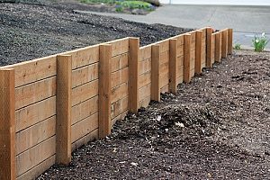a retaining wall that is built on fill dirt to keep plants upright and healthy while also protecting the yard