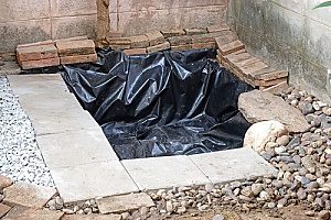 a backyard pond that is being built and has pond liner on it