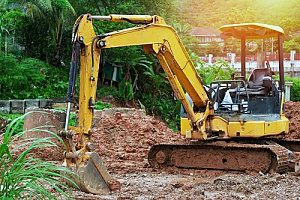 a pool removal contractor using an excavator to fill a backyard with fill dirt
