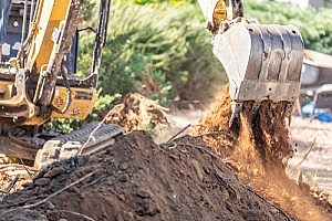 an excavator removing excess dirt from a construction site after the project