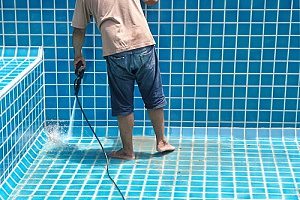 a man cleaning his inground pool and needs a pool removal