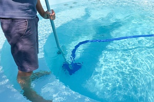 a man cleaning a pool with swimming pool problems