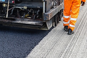 asphalt millings being laid on a road by contractors