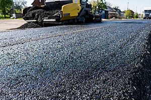 asphalt millings being spread across a road