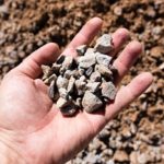 person holding crushed stone