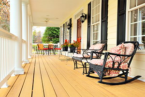 Low angle view of a large front porch with furniture and potted plants