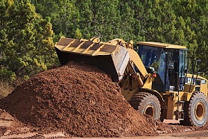 a bulldozer moving dirt to fill a hole in a yard