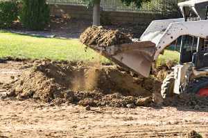 a Bulldozer filling dirt after pool removal