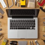 Construction tools all around a laptop. DIY outdoor projects concept