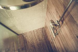 Running water from a showerhead. Constant exposure to water and moisture can ruin wood flooring bathroom