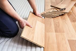 Worker installing laminated wood floor. Laminate flooring is one of the best flooring option for bathroom remodel