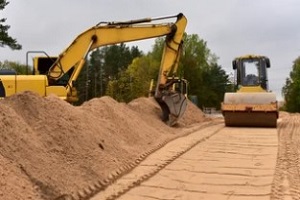 machine and jcb compacting the soil