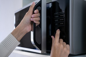 woman hands closing the microwave oven door