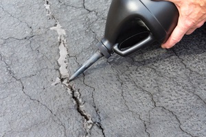 repairing cracks in driveway with asphalt crack filler