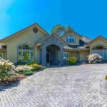 custom made luxury house with nicely landscaped and trimmed front yard and driveway