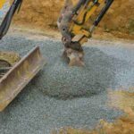 bucket shovel moving stones of foundation backfilling stone of foundation