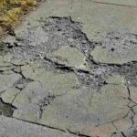 Broken concrete driveway in a condition of repair