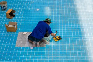 Technician repairing pool with his hand