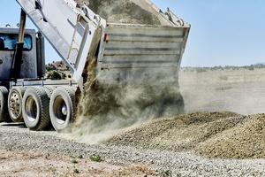A truck is unloading dirt gravel