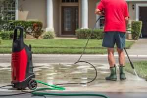 A man cleaning a driveway with a power washer