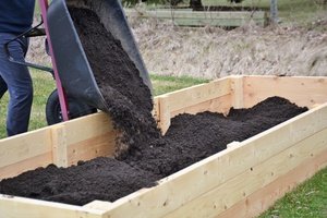 Filling raised garden bed with screened topsoil