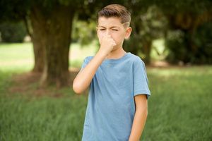 A boy experiencing a bad smell in the yard after the pool removal