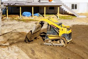 An excavator machine filling and leveling the dirt
