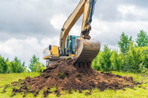 An excavator removing soil from the yard
