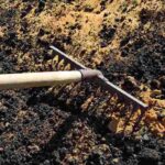 working garden rake is used to mix soil and sand for the vegetable garden